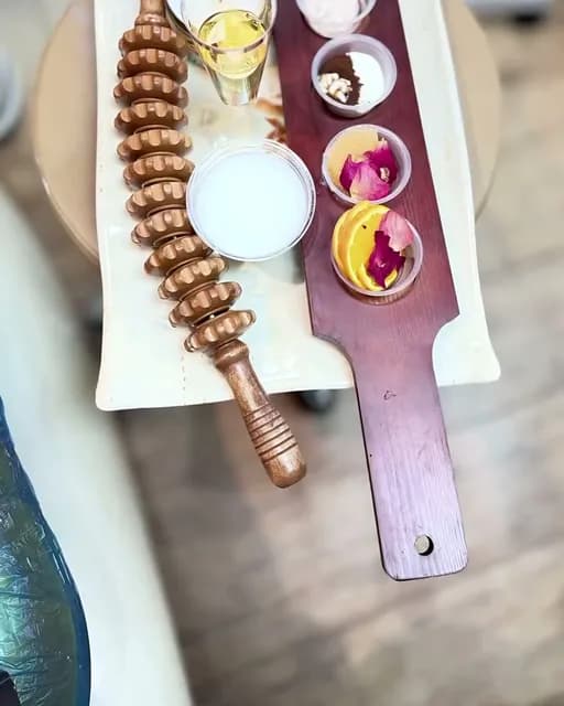 Pedicure tray with petals, lotion and a wooden massage roller